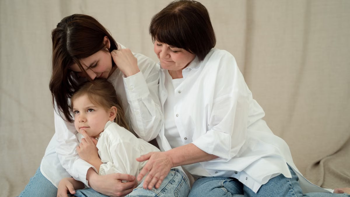 Heartwarming scene of three generations bonding in cozy jeans and white shirts, showcasing family love.